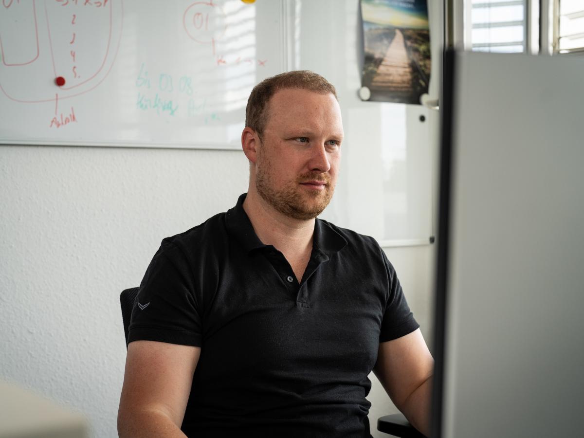 Mann konzentriert am Computer, um handlungsfähig zu bleiben bei IT-Problemen.