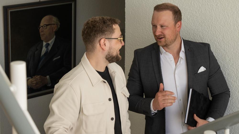 Zwei Männer im Büro sprechen über Resilienz in der IT.