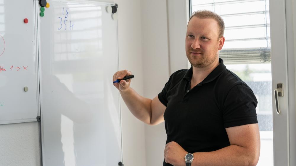 Ein Mann erklärt an einem Whiteboard das Szenario für die Krisenübung.