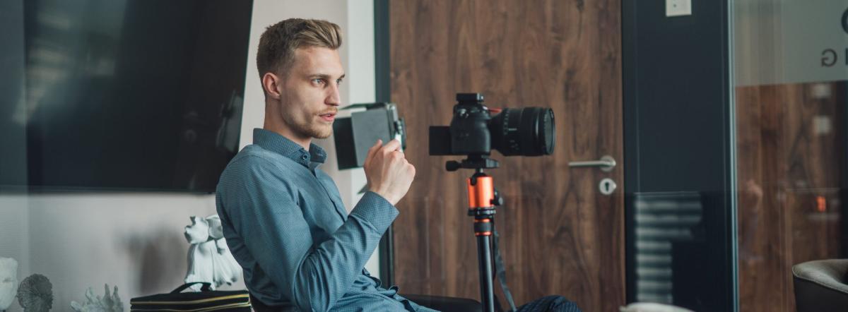 Mann mit Kamera zeigt, wie Video-Testimonials heute überzeugen.