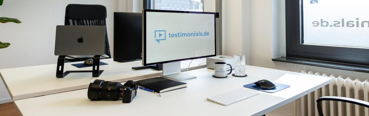 Ein Schreibtisch-Setup mit Computer und Kamera, ideal für Testimonials.