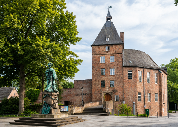 Das historische Gebäude im Energieanbieter-Test mit Statue im Vordergrund.