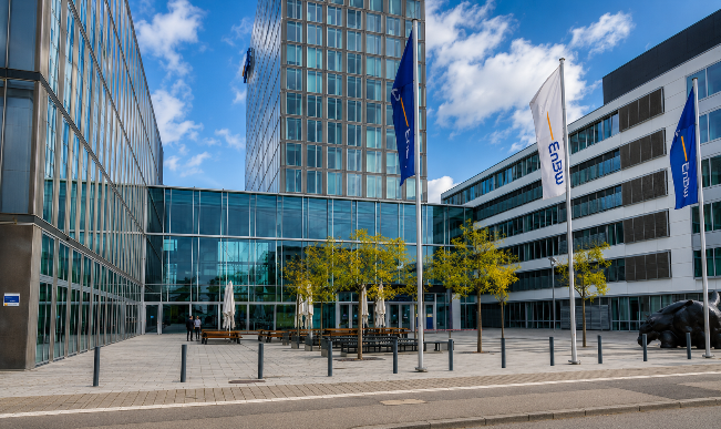 Aussenansicht des EnBW Gebäudes mit modernen Fassaden und Bäumen.
