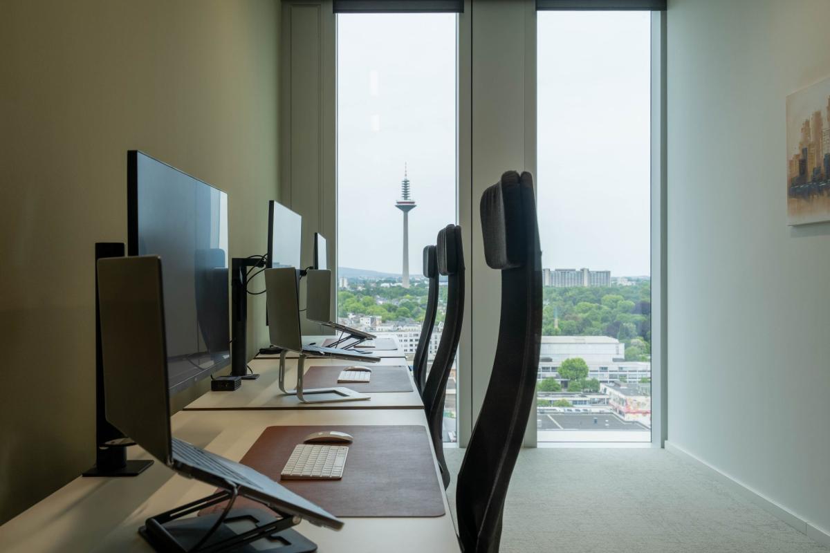Modernes Büro mit Computern und Blick auf die Stadt für Inhouse-Marketing.