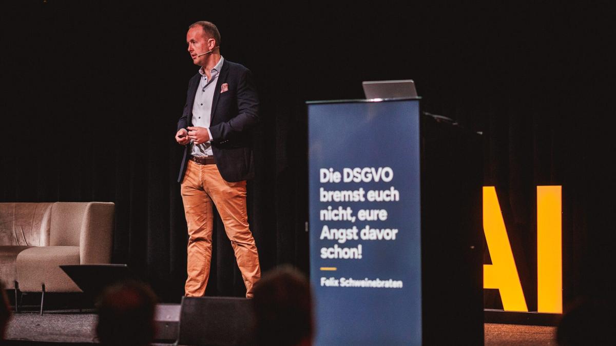 Vortrag über die DSGVO und datenschutzkonforme KI-Nutzung auf einer Bühne.