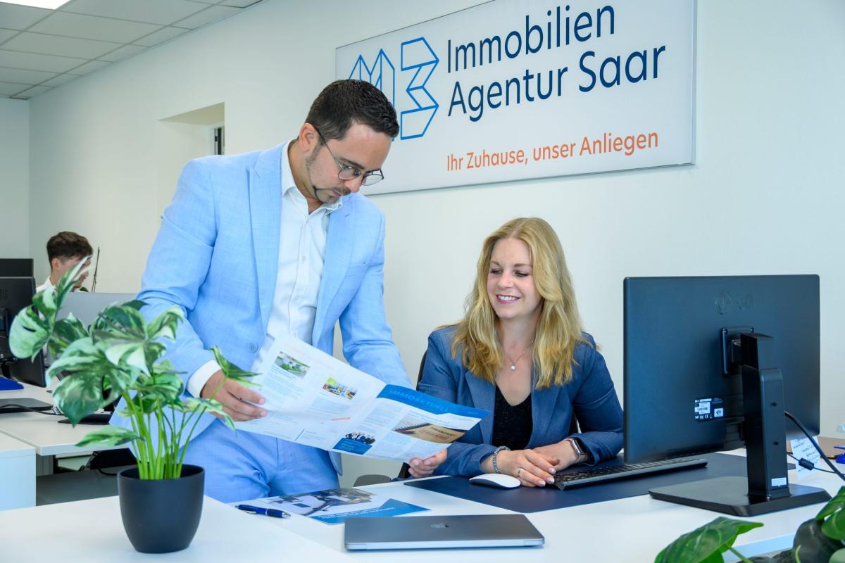 Berater und Kundin besprechen Wohnangebote bei der Immobilien Agentur Saar.