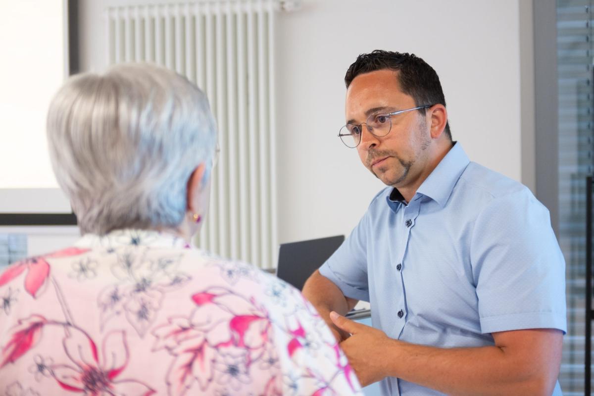 Eine Diskussion zum Thema Haus verkaufen in Saarlouis zwischen zwei Personen.