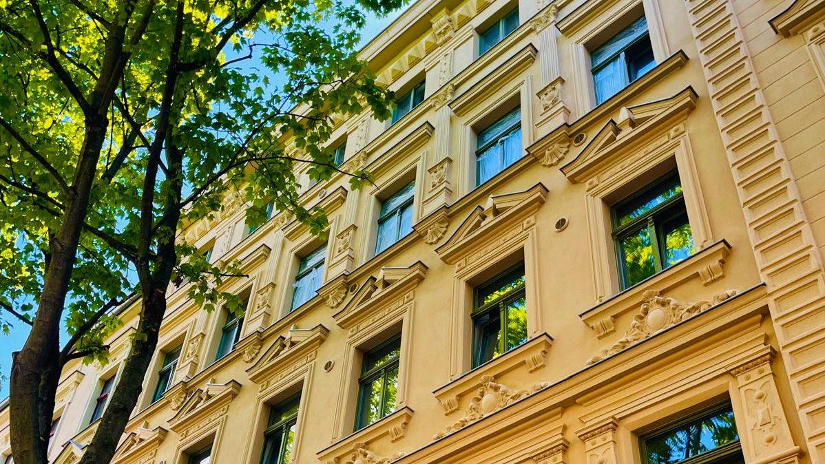 Fassade eines historischen Gebäudes mit vielen Fenstern und Verzierungen zur Denkmalimmobilie.