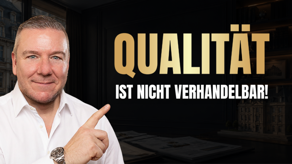Ein lächelnder Berater zeigt auf den Schriftzug „Qualität ist nicht verhandelbar“ vor einer Denkmalimmobilie.
