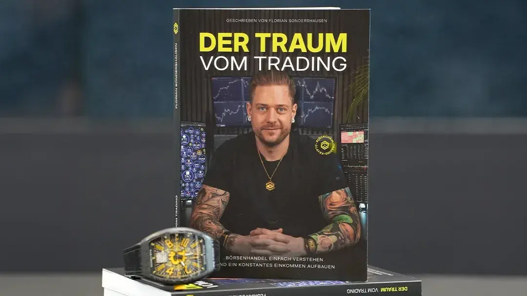 Das Buch 'Der Traum vom Trading' und eine stylische Uhr auf dem Tisch.
