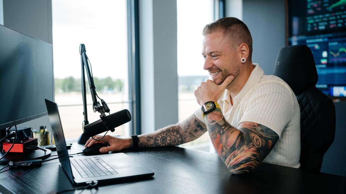 Ein Mann am Laptop bei der Trading Ausbildung, fokussiert und glücklich.