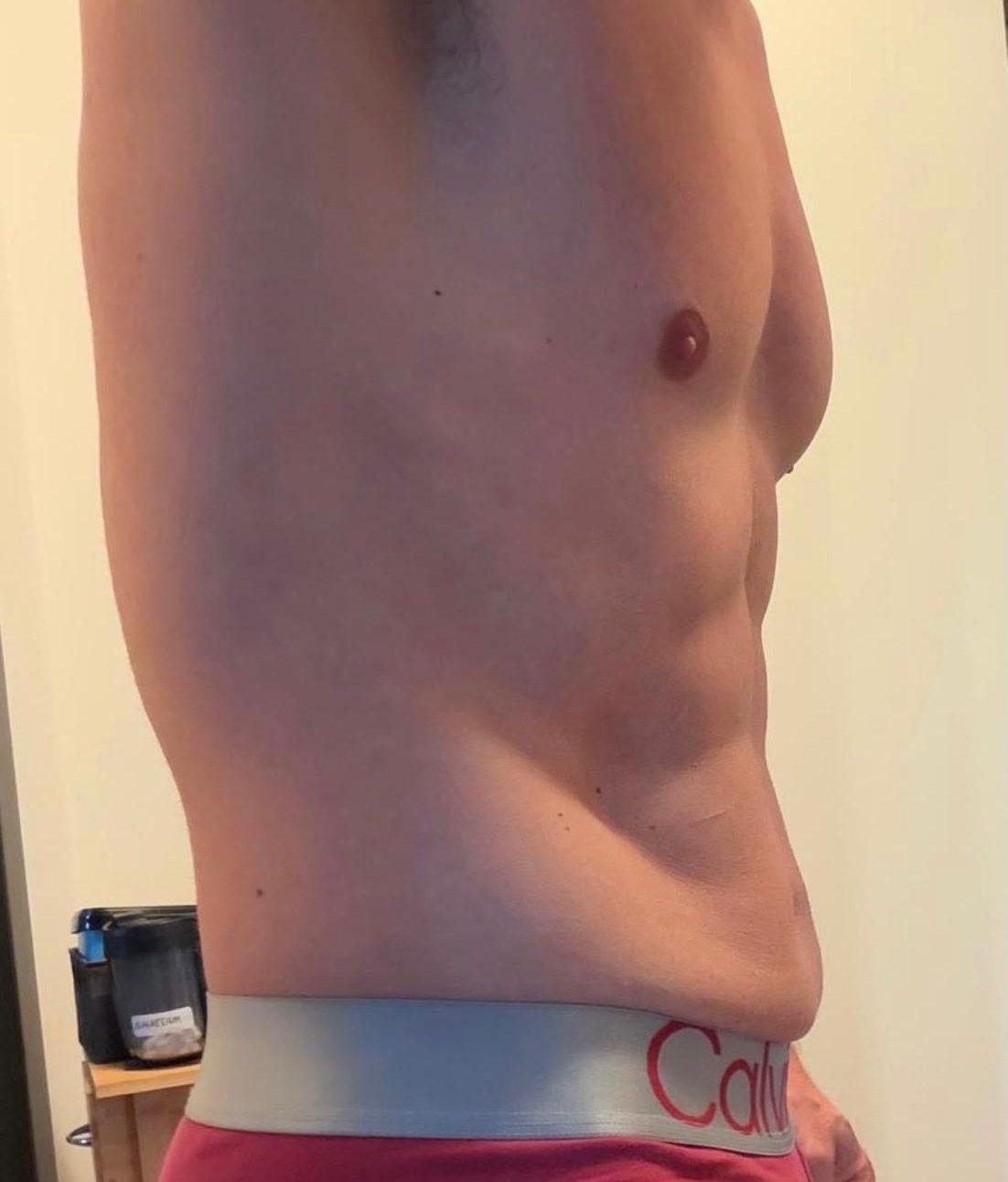 Mann mit sichtbar definiertem Bauch zeigt Fortschritte beim Bauchfett verlieren.