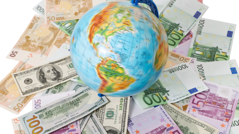 Ein Globus liegt auf Euro- und Dollarscheinen – ein Sinnbild dafür, Vermögen internationalisieren zu wollen.
