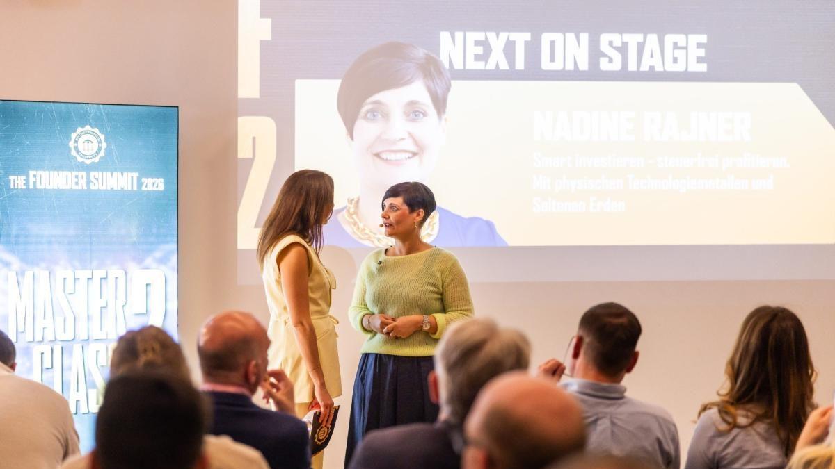 Zwei Frauen auf der Bühne bei einer Präsentation über das Thema 'Was tun mit dem Geld'.