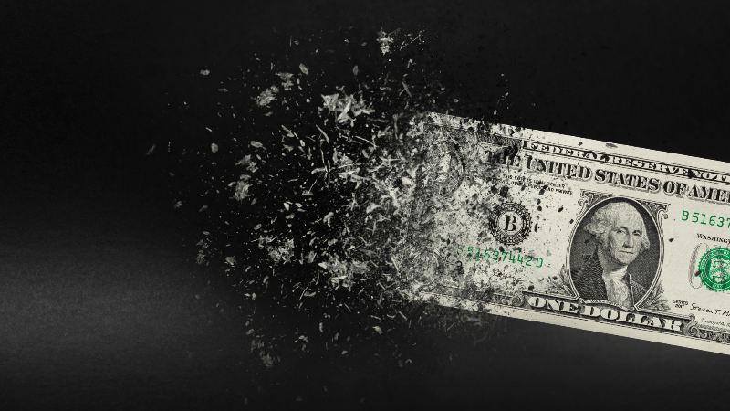 Ein zerstreuter Dollar-Schein symbolisiert die Herausforderungen beim Vermögen aufstellen.