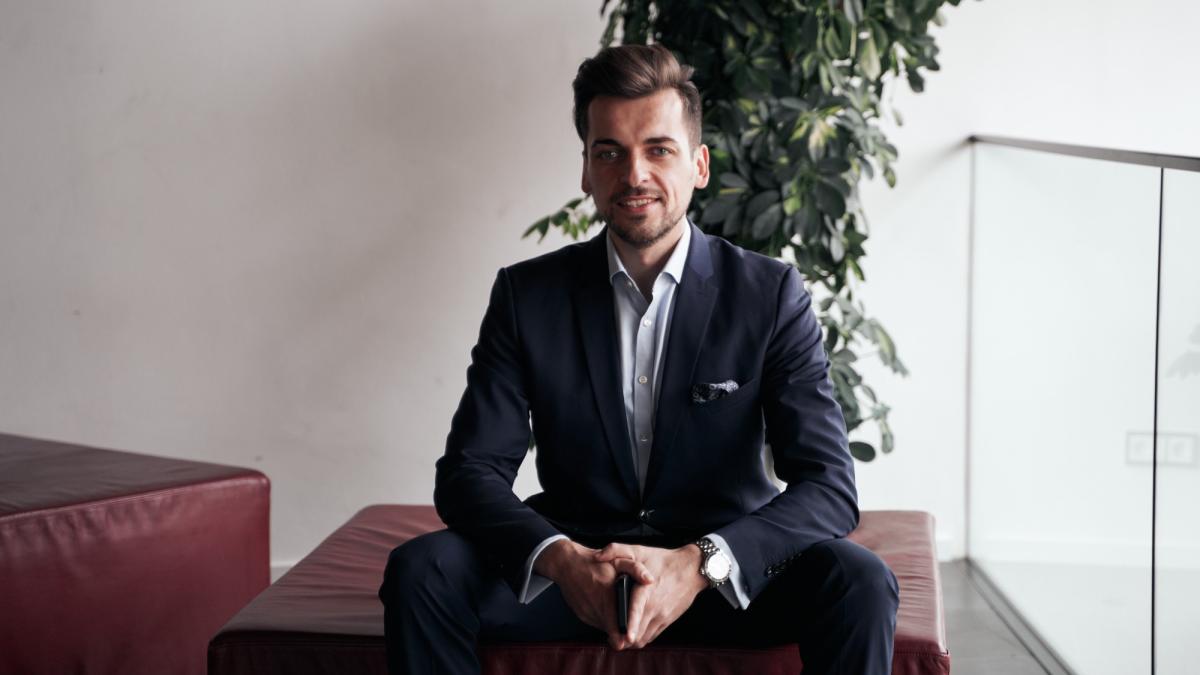 Ein Geschäftsmann in einem Anzug sitzt entspannt und betrachtet die Fonds Konwave Gold Equity.