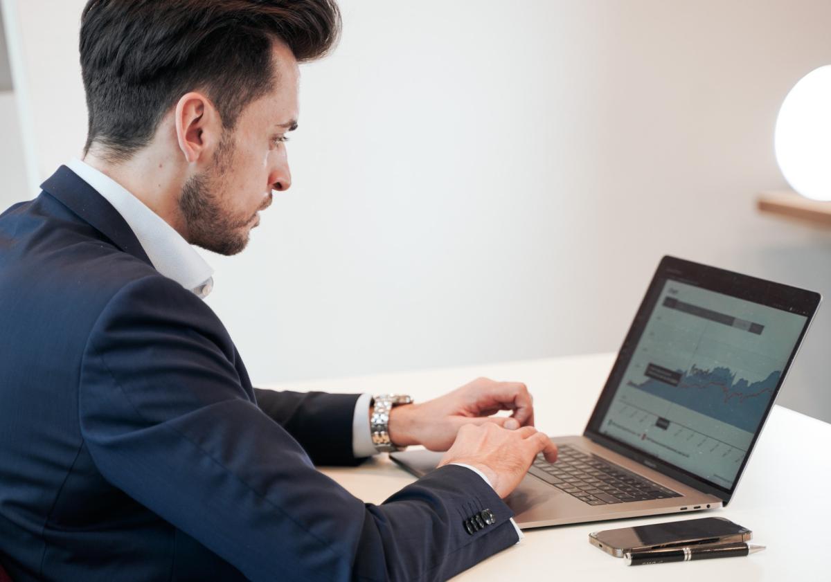 Mann arbeitet am Laptop und informiert sich über Lebensversicherung kündigen.