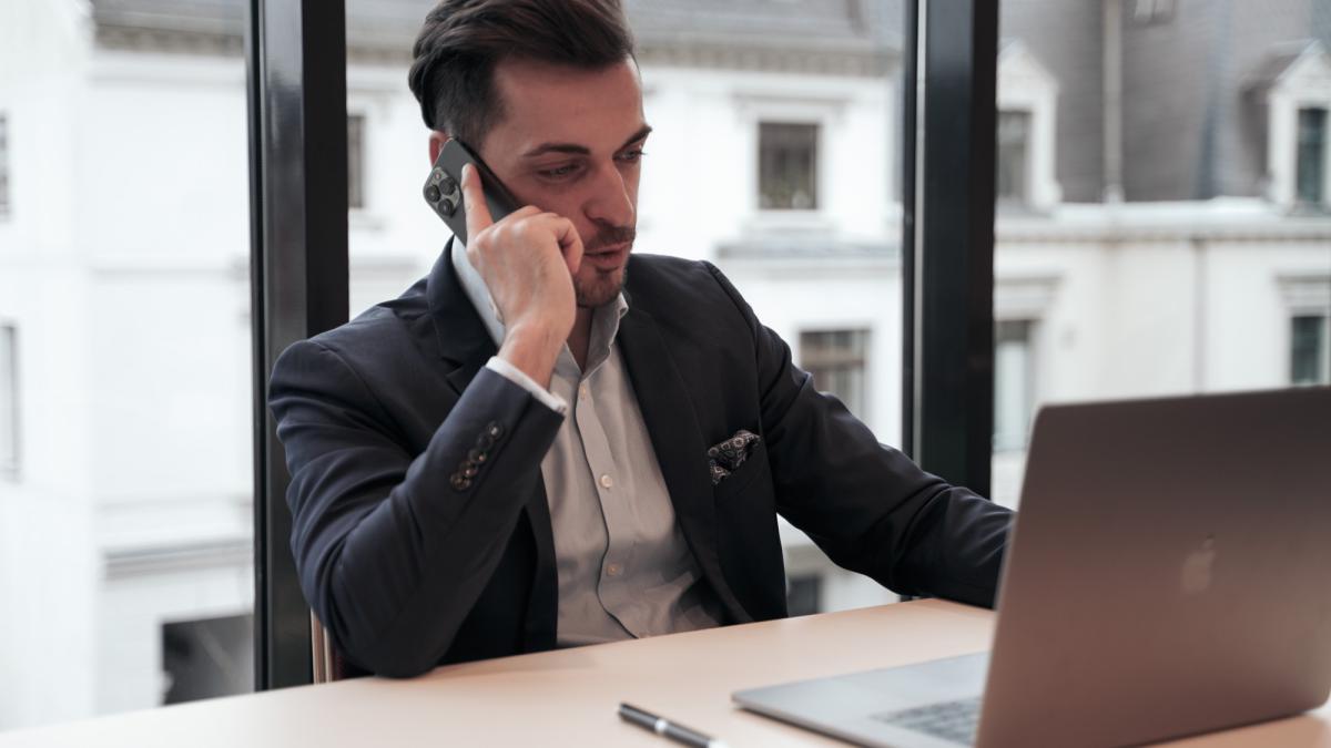 Mann am Telefon, während er über den Kauf einer privaten Immobilie nachdenkt.