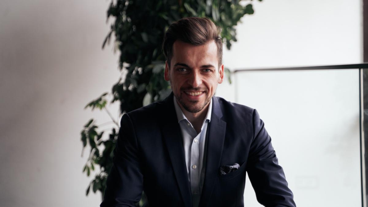 Experte in Anzug lächelt, während der DWS Top Dividende diskutiert wird.