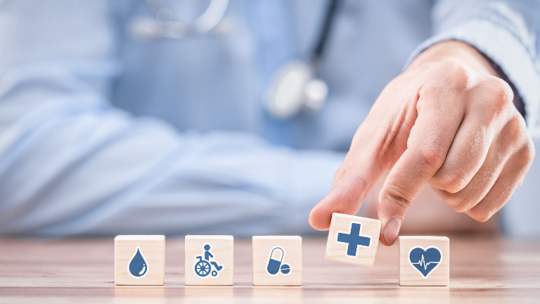 Eine Hand platziert einen Würfel mit einem Gesundheitssymbol beim PKV-Wechsel nach Scheidung.