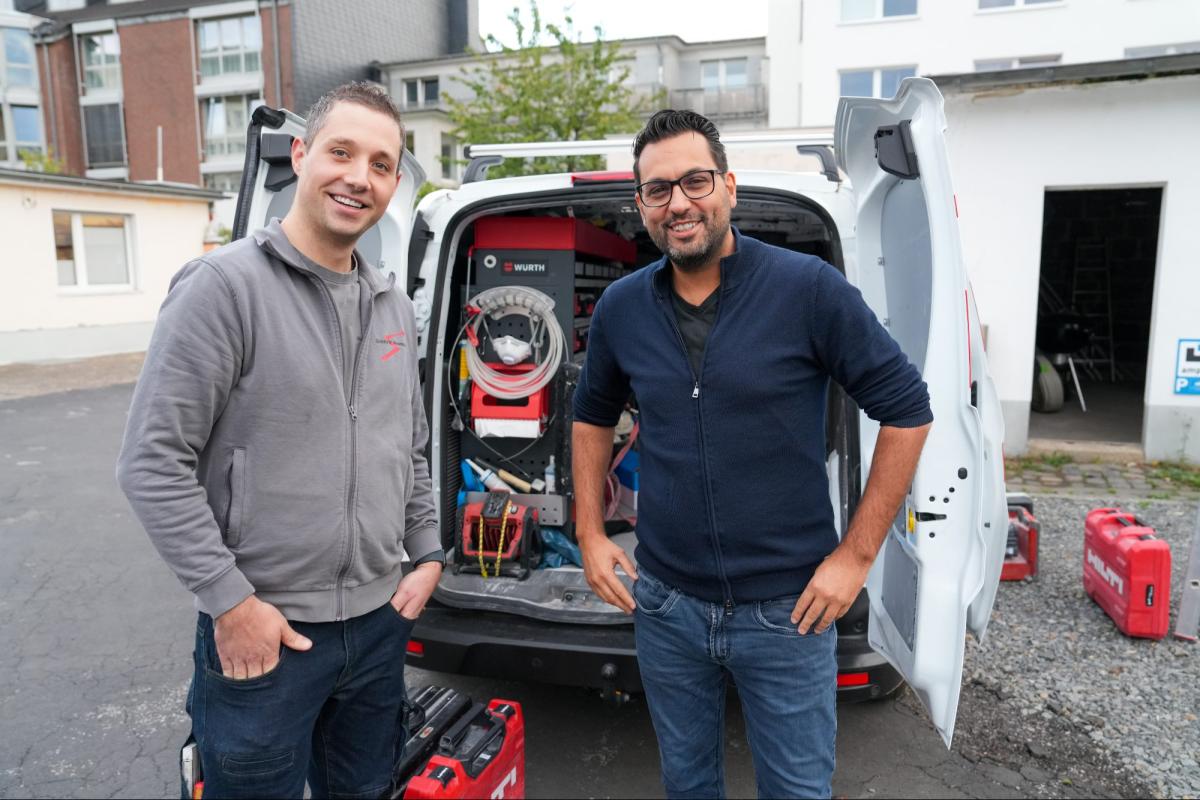 Zwei Handwerker stehen vor einem Handwerksfahrzeug zur Gewinnsteigerung im Handwerksbetrieb.