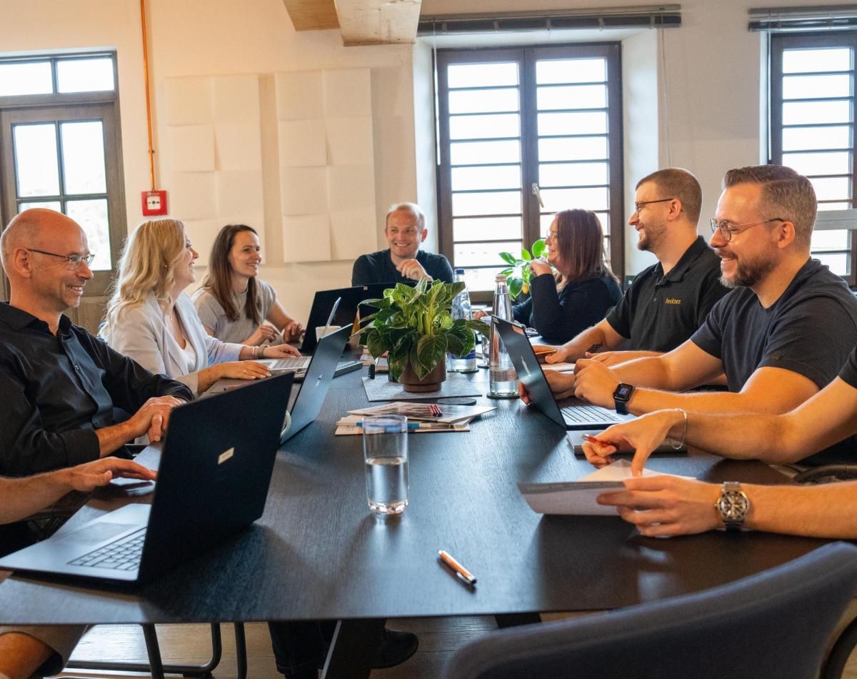Betriebsklima als Motivationsfaktor: Ein Teil des Teams der Unternehmensberatung Heckner im Austausch während eines Team-Meetings