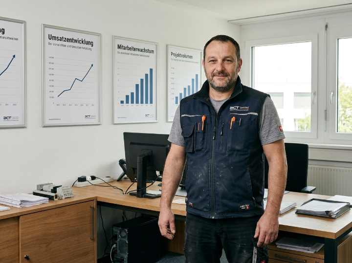 Mann im Büro mit Diagrammen zur Unternehmensentwicklung im Handwerk.