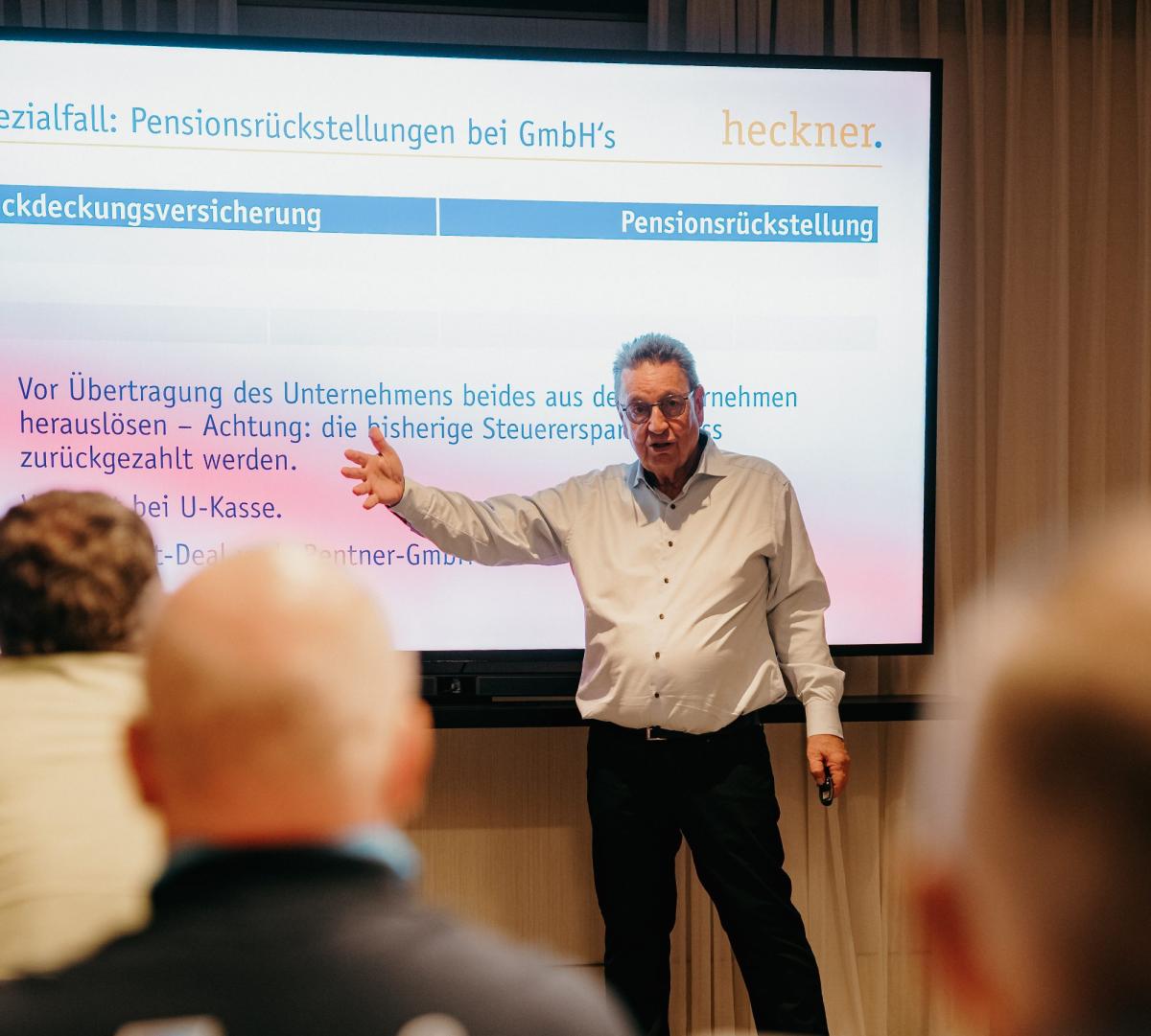 Experte erläutert Unternehmensverkauf im Handwerk während einer Präsentation.