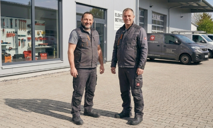 Zwei Handwerker stehen am Firmenstandort im Rahmen des Unternehmensverkaufs im Handwerk.