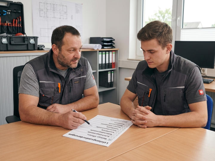 Zwei Handwerker besprechen die Eingruppierungshilfe im Handwerk.