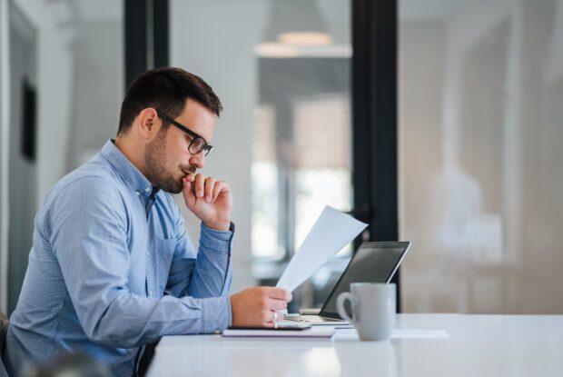 Mann am Arbeitsplatz reflektiert über Funktionieren und Gestalten.