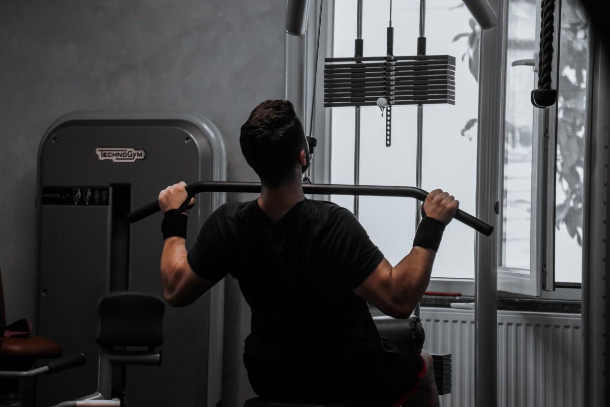 Mann beim Krafttraining im Fitnessstudio, der dranbleiben beim Sport will.
