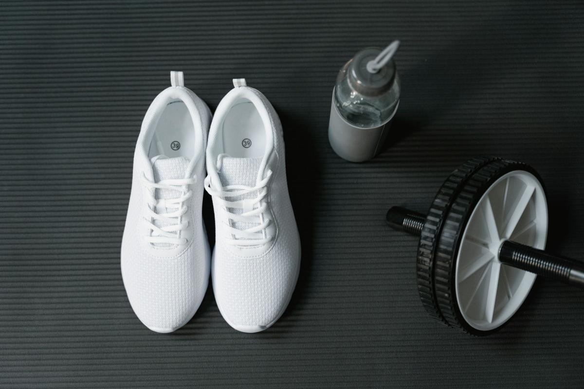 Weisse Turnschuhe, Wasserflasche und Trainingsgerät für Sport für Selbständige.