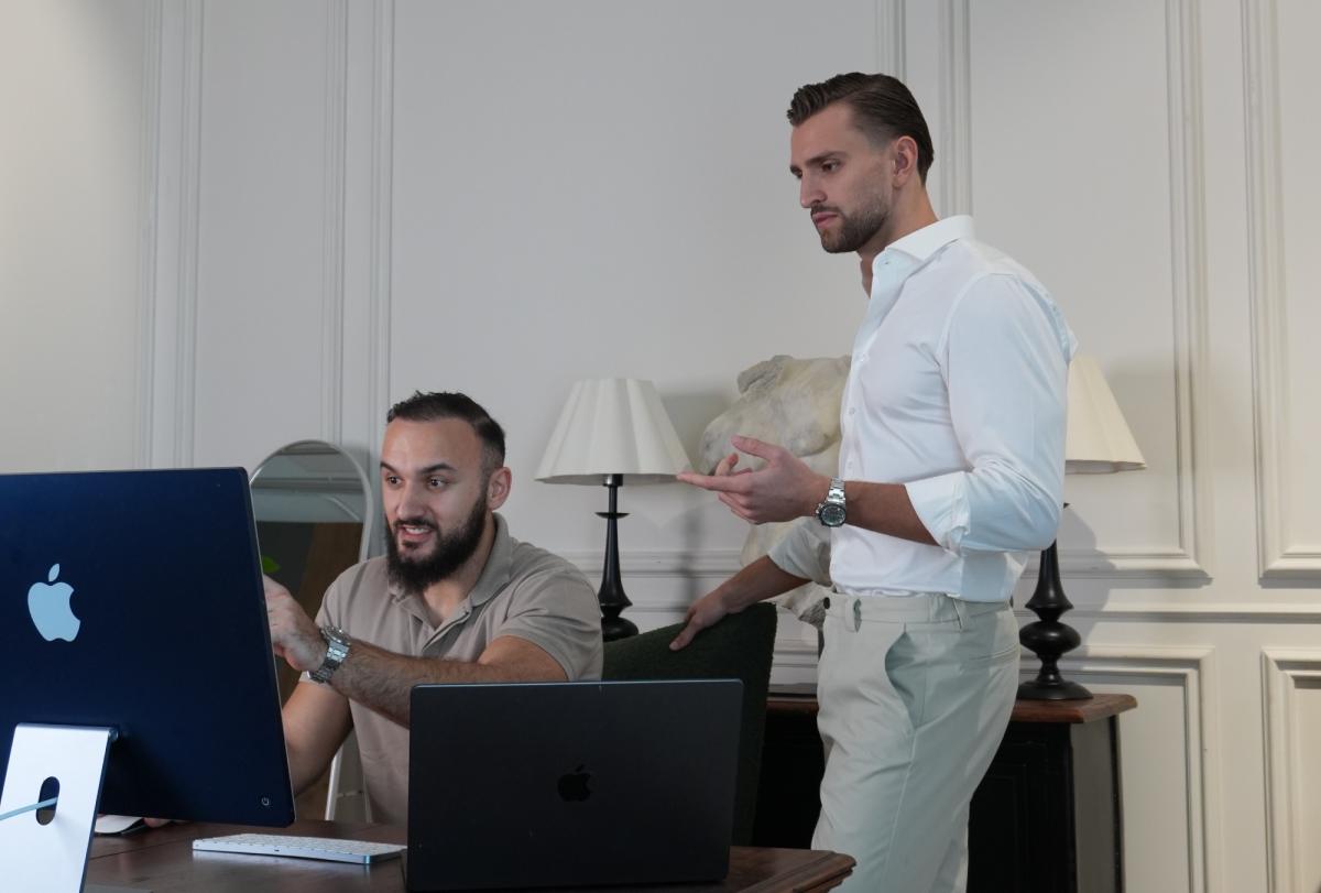 Zwei Männer diskutieren über Trading am Computer, während sie die Seriösität von Kilian Kropiunik hinterfragen.
