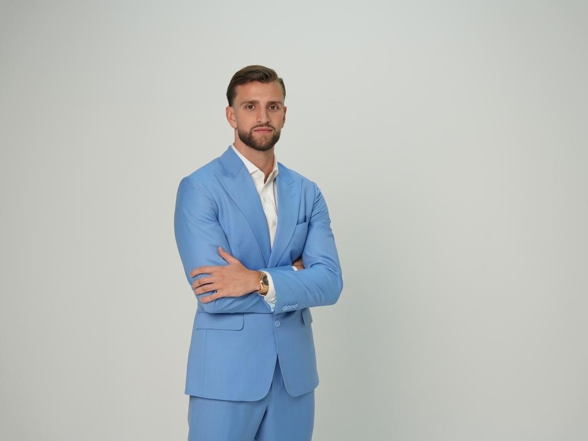 Kilian Kropiunik präsentiert sich in einem blauen Anzug.
