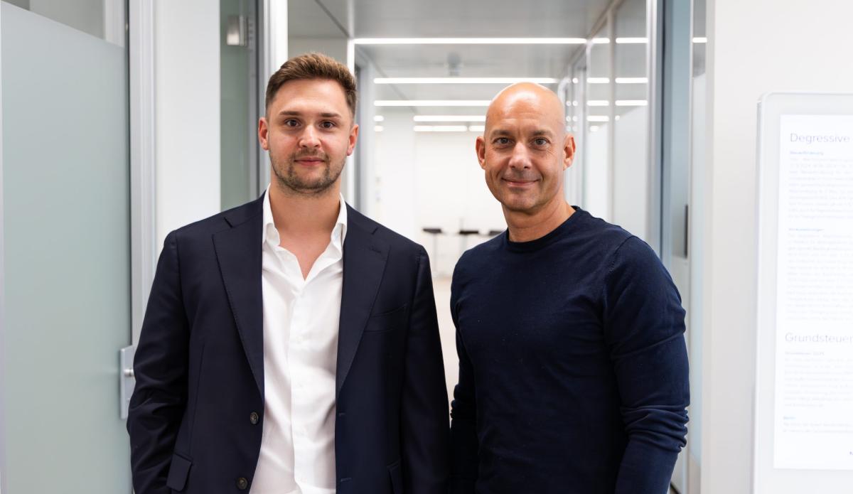 Zwei Männer in Anzügen stehen in einem modernen Büro zur Mandantengewinnung über Instagram.