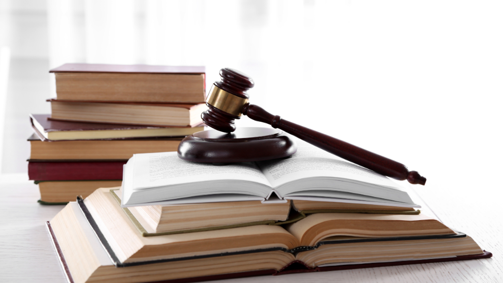 Stapel von Jurabüchern mit einem Richtershammer, Thema EU AI Act.
