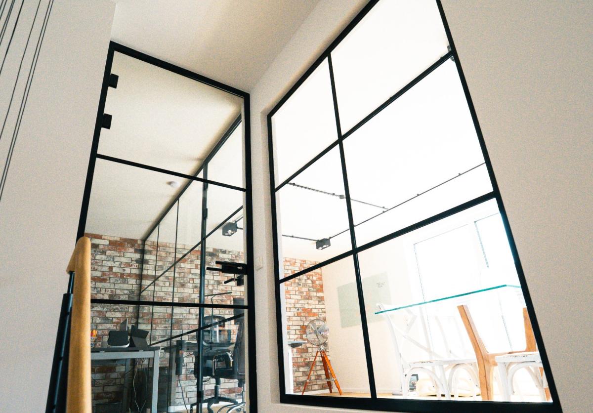 Moderne Loft-Trennwand im Industrial Style mit klaren Sprossen und schwarzem Profil.