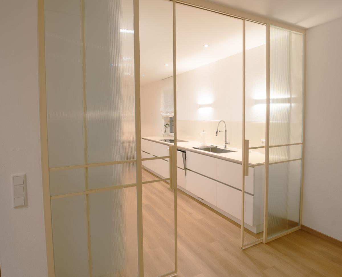 Moderne Schiebetür in der Glastrennwand zur Küche.