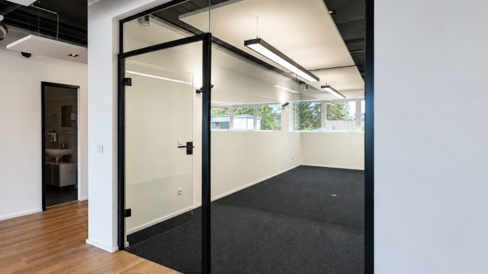 Moderne Büroumgebung mit Glastrennwänden für Schallschutz.