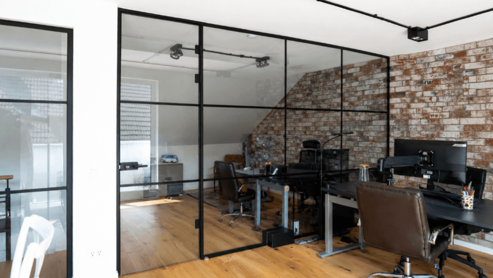 Moderne Loft-Trennwand aus Glas in einem Büro mit Holzfußboden.