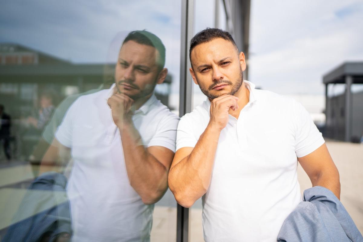 Mann in weißem Poloshirt denkt über Generation Z in der Pflege nach.