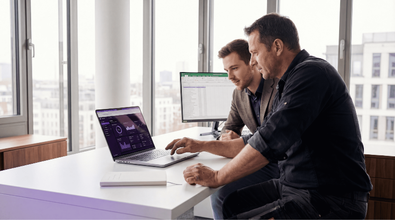 Marketing Manager und Kunde schauen auf Dashboard.