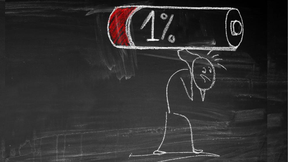 Eine Zeichnung eines Menschen, der schwer unter der Last einer Batterie mit 1% steht, symbolisiert inneren Erfolg.