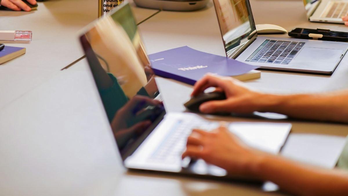 Person tippt auf Laptop und arbeitet an Digital Branding.