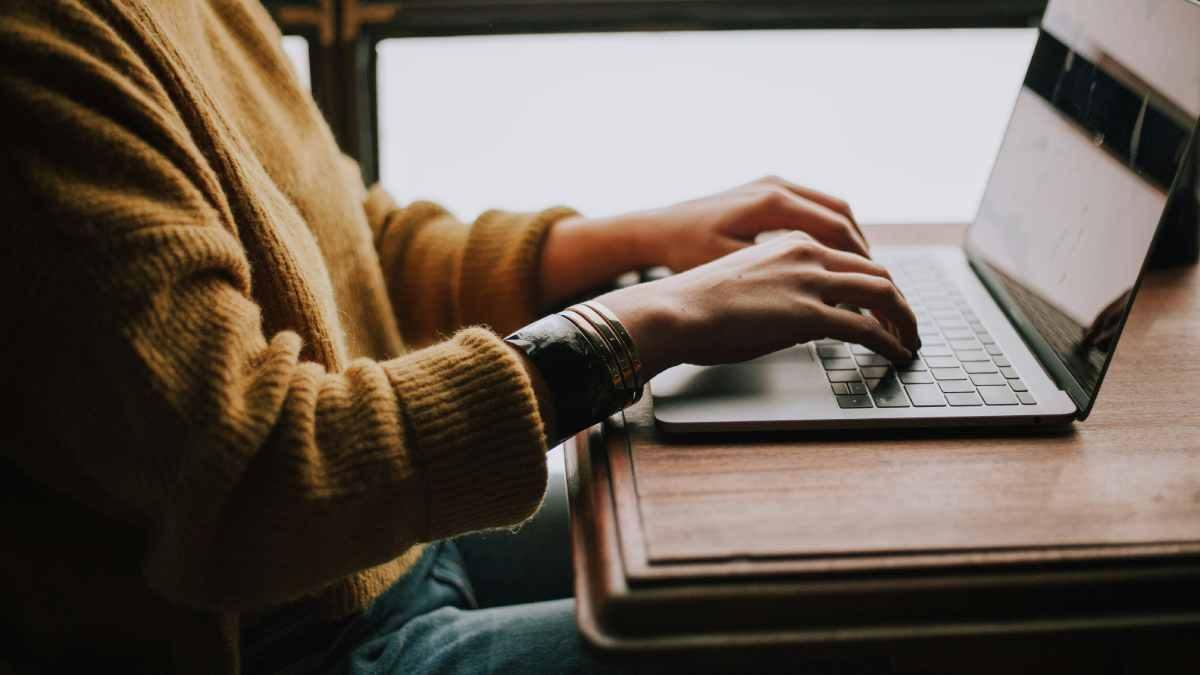Eine Person tippt auf einem Laptop und arbeitet am B2B Webshop erstellen.