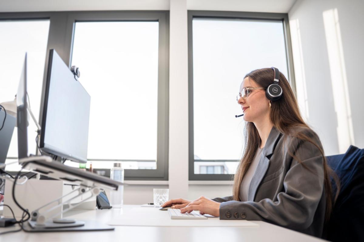 Eine Frau nutzt ein CRM-System am Computer im Büro.