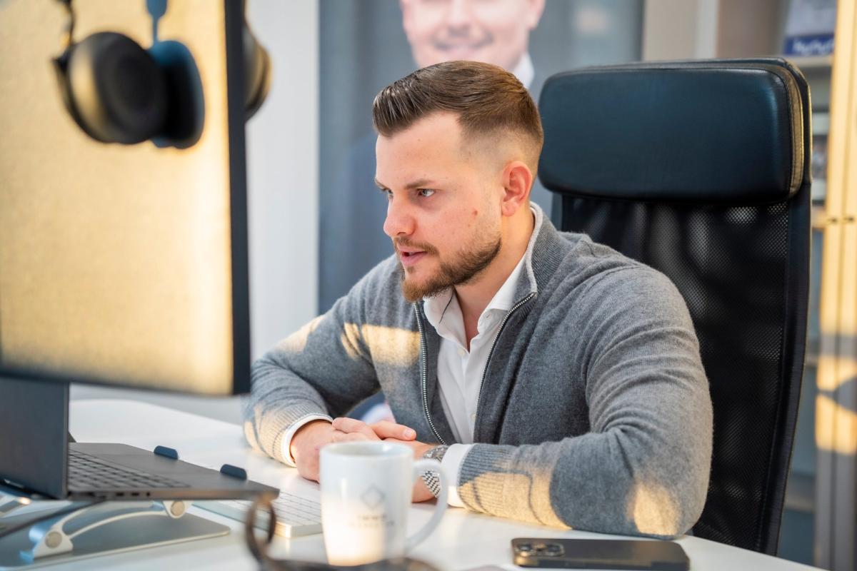 Ein Mitarbeiter am Computer arbeitet an Prozessen im Unternehmen.