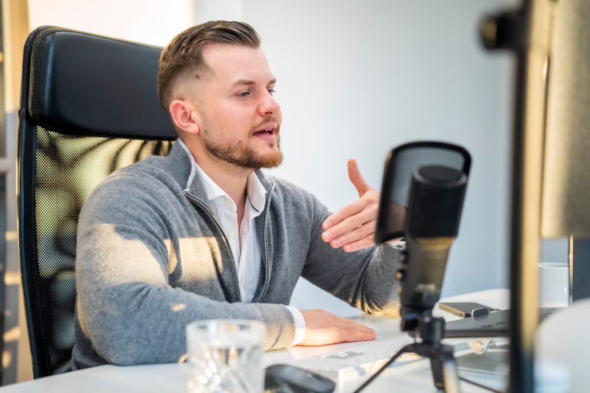 Mann erläutert Bauträger Marketing Vorleistung in einem Büro.