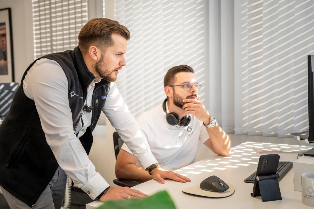 Zwei Männer diskutieren über Immobilienmarketing über Social Media.